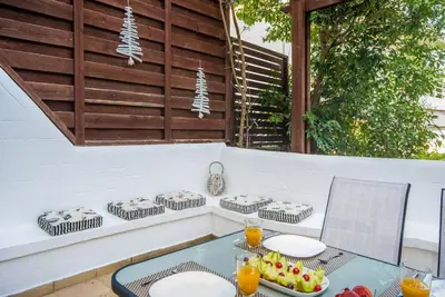 a table with plates and fruit on a patio at Family Getaway Home in Rhodes Town