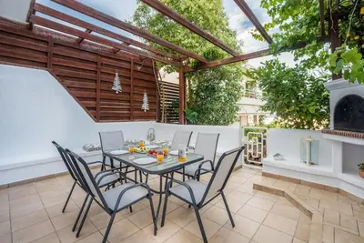 a patio with a table and chairs and a fireplace at Family Getaway Home in Rhodes Town