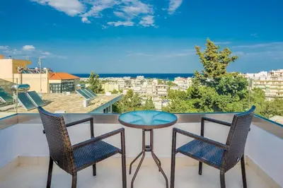 a balcony with two chairs and a table and a view at Family Getaway Home in Rhodes Town