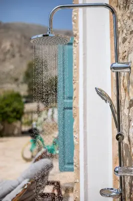 a shower head hanging from the side of a building at Lady Stamatias House in Halki