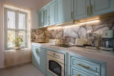 a kitchen with blue cabinets and a sink at Lady Stamatias House in Halki