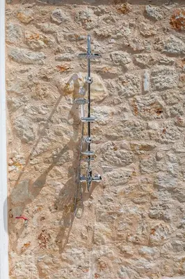a stone wall with a metal pole on it at Lady Stamatias House in Halki