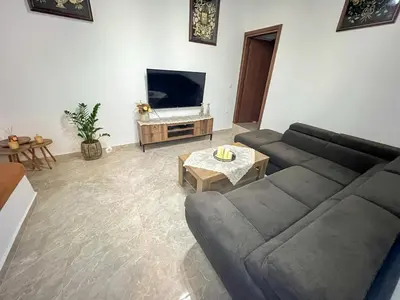 a living room with a couch and a tv at La Casa di villagio in Koskinou