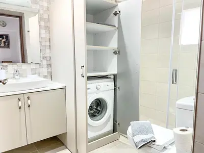 a white bathroom with a washer and dryer at La Casa di villagio in Koskinou