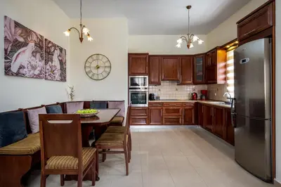 a kitchen with a table and a refrigerator at Hermes' Getaway Plimmiri in Plimmiri