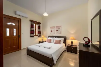 a bedroom with a large bed and a television at Hermes' Getaway Plimmiri in Plimmiri