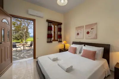 a bedroom with a large bed and a patio at Hermes' Getaway Plimmiri in Plimmiri