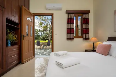 a bedroom with a bed and a door to a patio at Hermes' Getaway Plimmiri in Plimmiri