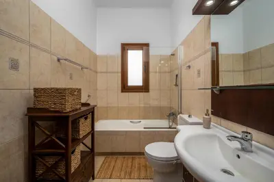 a bathroom with a sink and a toilet and a tub at Hermes' Getaway Plimmiri in Plimmiri