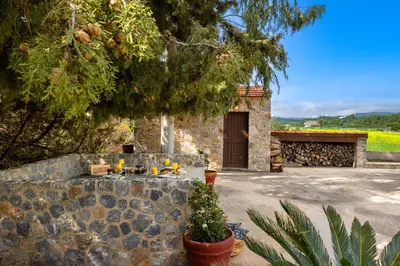 a stone building with a table with oranges on it at Hermes' Getaway Plimmiri in Plimmiri