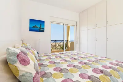 a bedroom with a bed with a view of the ocean at Villa Alexi in Kalathos