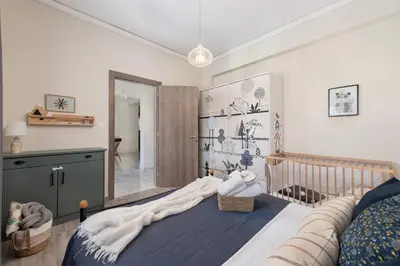 a baby room with a crib and a bedroom with at Christos House in Afantou