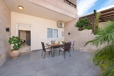 a patio with a wooden table and chairs at Christos House in Afantou