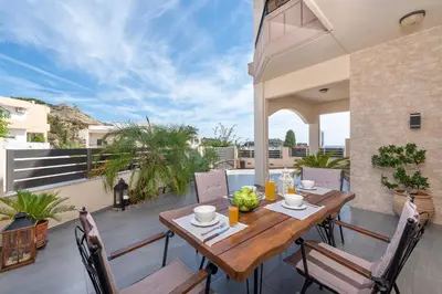 a wooden table on the balcony of a house at Christos House in Afantou