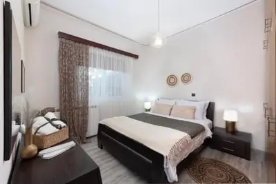 a bedroom with a large bed and a window at Christos House in Afantou