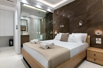 a bedroom with a large bed and a shower at Rhodes SkyLine Suite with out Door Jacuzzi Sea View A1 in Ixia