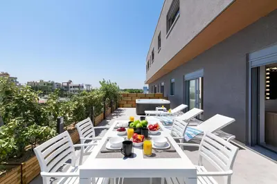 a white table and chairs on the balcony of a building at Rhodes SkyLine Suite with out Door Jacuzzi Sea View A1 in Ixia