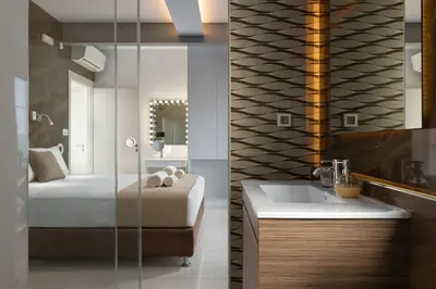 a bathroom with a bed and a sink and a mirror at Rhodes SkyLine Suite with out Door Jacuzzi Sea View A1 in Ixia