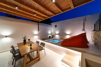 a living room with a table and a swimming pool at Atria luxury experience in Kattavía