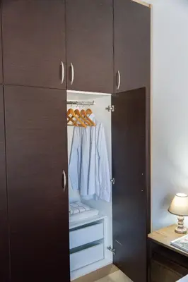 a closet with brown cabinets and shoes in it at Ismini Luxury Villa in vlicha