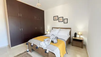 a bedroom with a large bed with a yellow blanket at Ismini Luxury Villa in vlicha