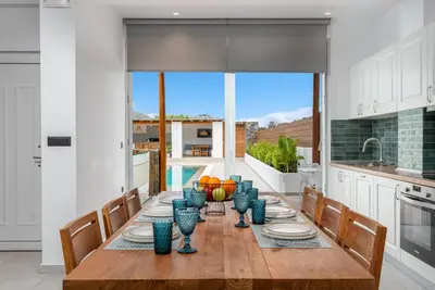 a dining room with a table with blue vases on it at JOHANNES LUXURY VILLAS in Kolimbia