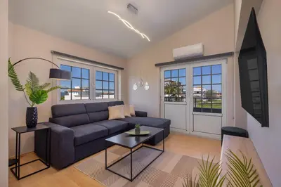 a living room with a blue couch and a table at Coral Paradise Luxury Modern Family Villa with Jacuzzi, Pool View & Parking in Rhodes Island in Kremasti