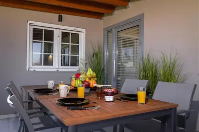 a wooden table with glasses of orange juice on it at Coral Paradise Luxury Modern Family Villa with Jacuzzi, Pool View & Parking in Rhodes Island in Kremasti