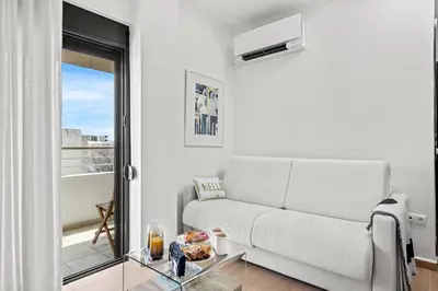 a white living room with a couch and a glass table at Casa Di Natalia in Rhodes Town