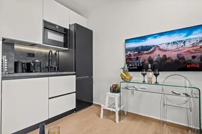 a kitchen with white cabinets and a glass table at Casa Di Natalia in Rhodes Town