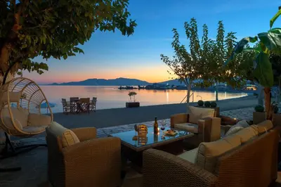 a patio with chairs and a table with a view of the water at Villa Haraki Paradise in Haraki