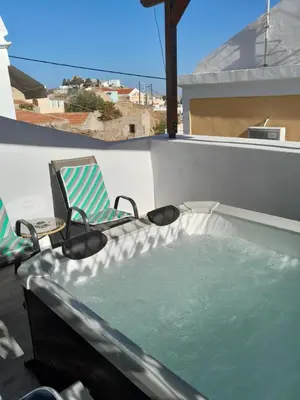 a hot tub on a balcony with a chair at 