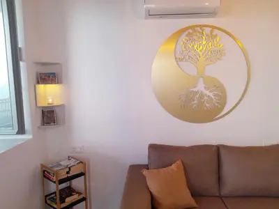 a living room with a couch and a tree on the wall at 