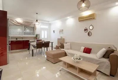 a living room with a couch and a table at Pearl of Stegna - Beach House in Archangelos