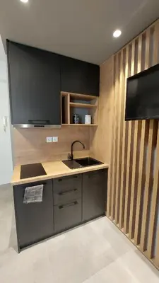 a kitchen with a sink and a tv on a wall at Amerikis Central Apart in Rhodes Town