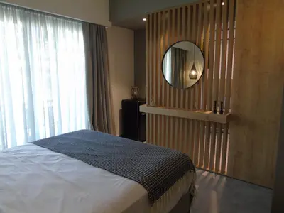 a bedroom with a bed and a mirror on the wall at Amerikis Central Apart in Rhodes Town