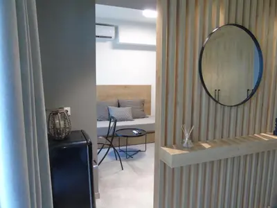a mirror on a wall next to a room at Amerikis Central Apart in Rhodes Town