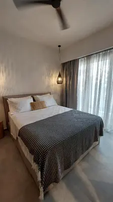 a bedroom with a large bed with a ceiling fan at Amerikis Central Apart in Rhodes Town