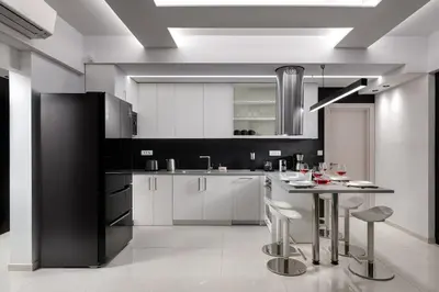 a kitchen with white cabinets and a table with stools at Rhodes Skyline Suite with In Door Jacuzzi Sea View in Ixia