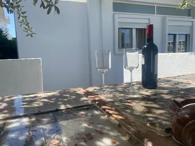 a bottle of wine and two glasses on a table at Flowers Lullaby Loft in Afantou