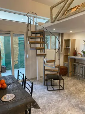 a dining room with a spiral staircase and a table at Flowers Lullaby Loft in Afantou