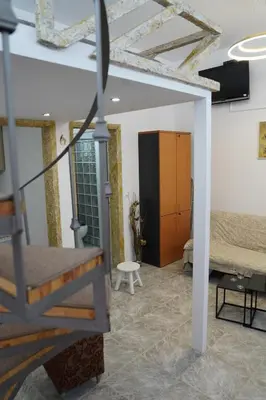 a living room with a staircase and a bedroom at Flowers Lullaby Loft in Afantou