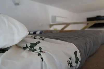 a bed with a blanket on top of it at Flowers Lullaby Loft in Afantou