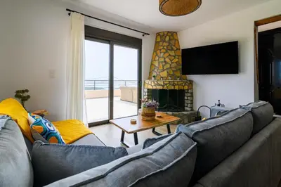 a living room with a couch and a fireplace at Arsithea Villa in Monólithos