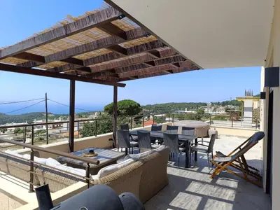a patio with a table and chairs on a roof at Arsithea Villa in Monólithos