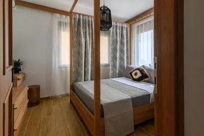 a bedroom with a canopy bed with a window at Arsithea Villa in Monólithos