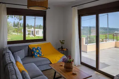 a living room with a couch and a large window at Arsithea Villa in Monólithos