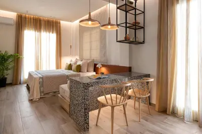 a bedroom with a bed and a table and chairs at HELENA’S RETREAT in Rhodes Town