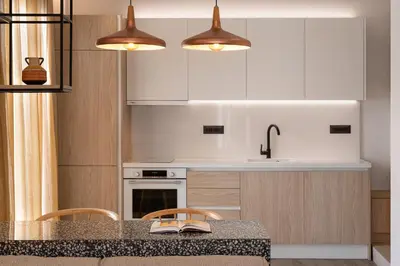 a kitchen with white cabinets and a table with chairs at HELENA’S RETREAT in Rhodes Town