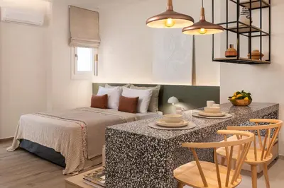 a bedroom with a bed and a table with chairs at HELENA’S RETREAT in Rhodes Town